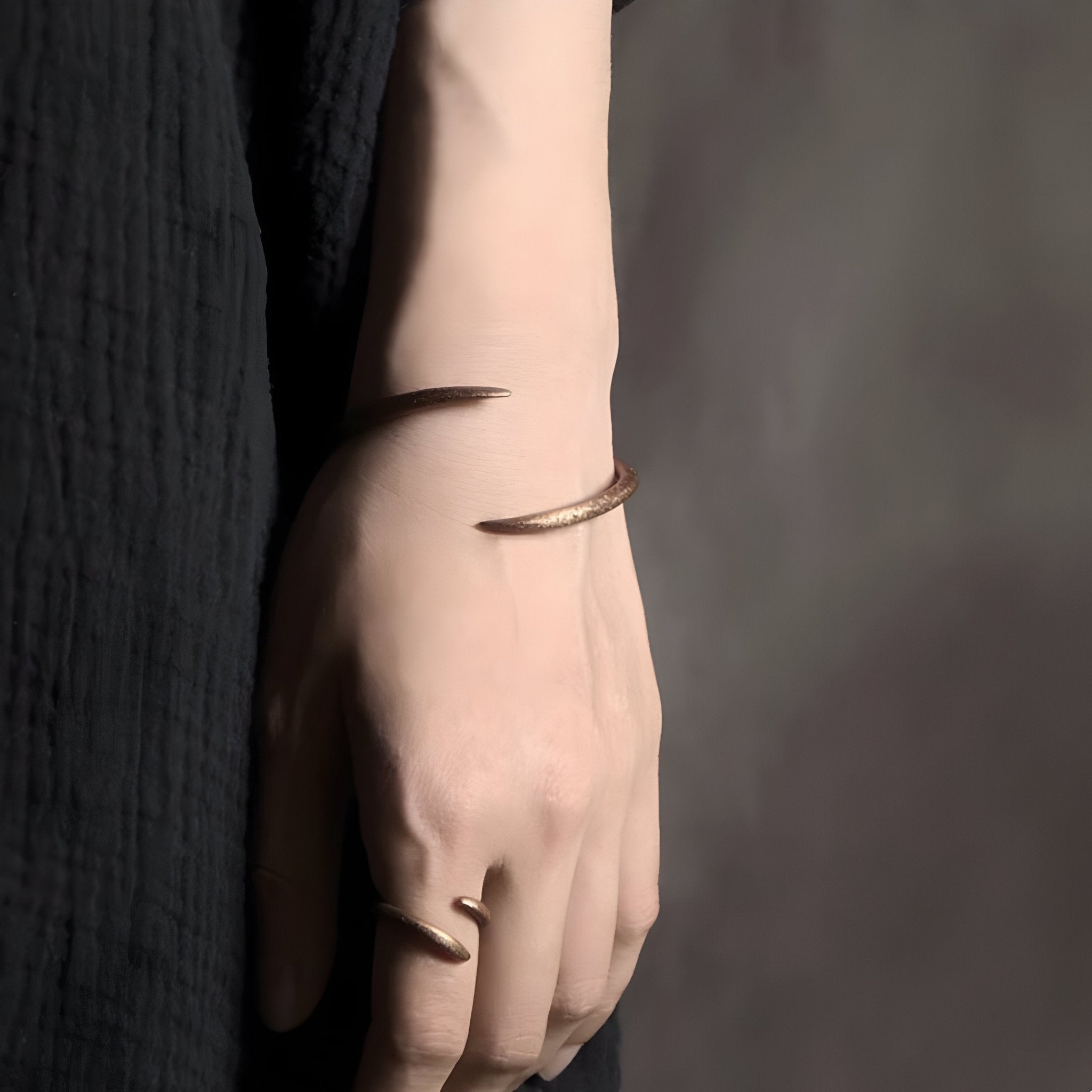 Bracelet jonc torsadé en cuivre marron porté au poignet, style vintage et minimaliste.