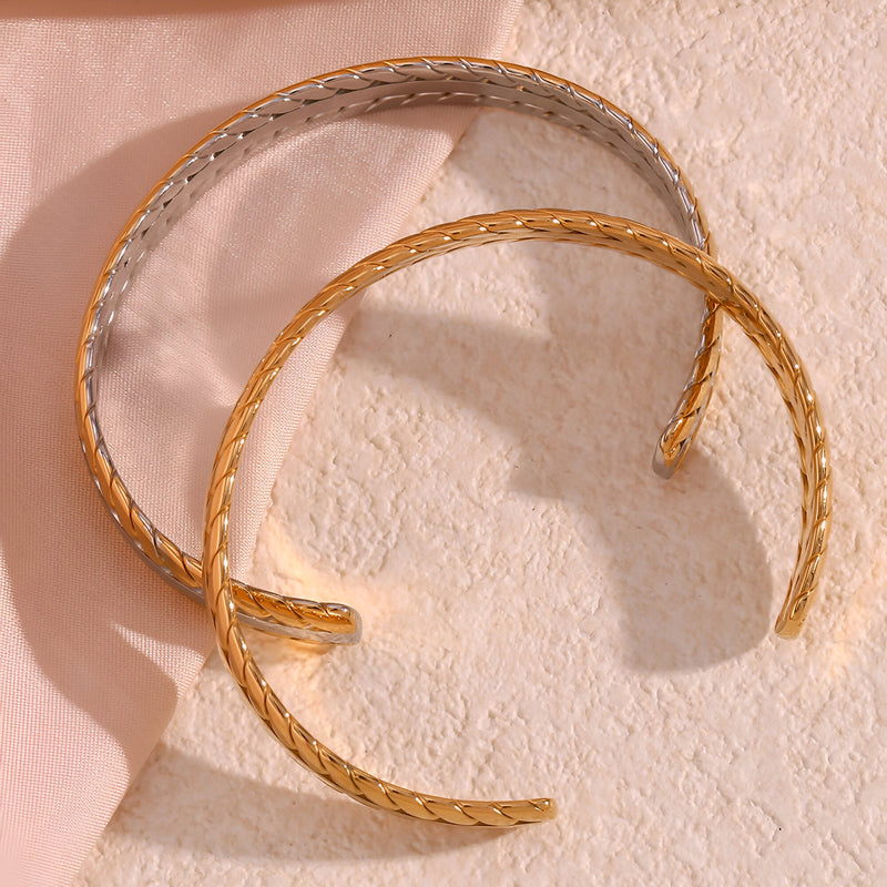 Bracelet jonc tressé en acier inoxydable plaqué or et argent, style fin et élégant.