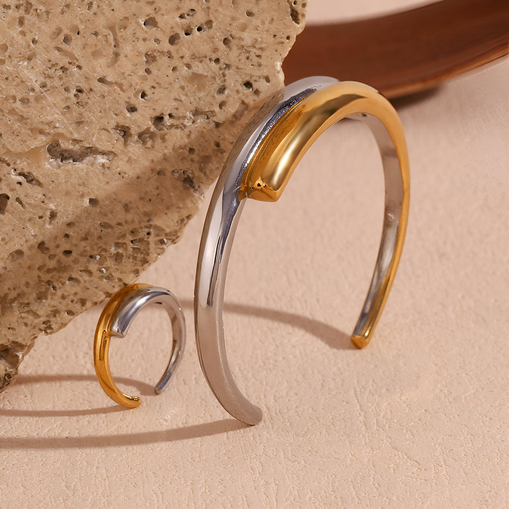 Bracelet jonc ouvert en acier inoxydable bicolore or et argent, design épuré et harmonieux.