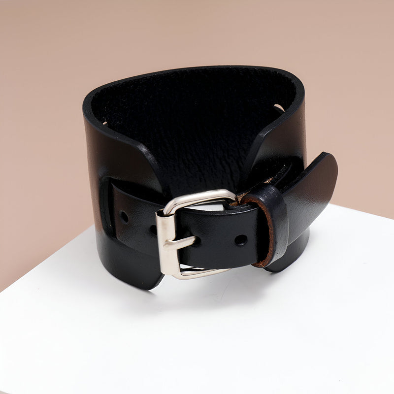 Bracelet large en cuir noir pour homme avec boucle ardillon argentée et finition lisse.
