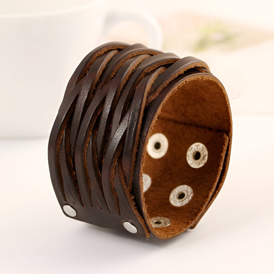 Bracelet large en cuir café texturé, design tressé avec boutons-pression métalliques, style masculin.
