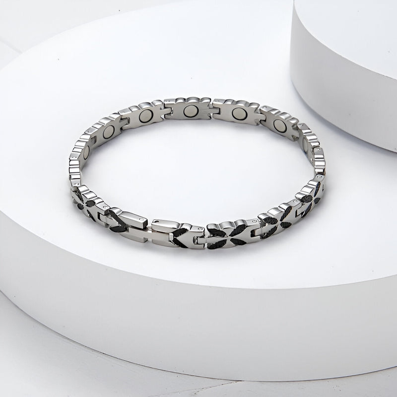 Bracelet magnétique en titane argenté avec maillons gravés et aimants visibles côté intérieur.