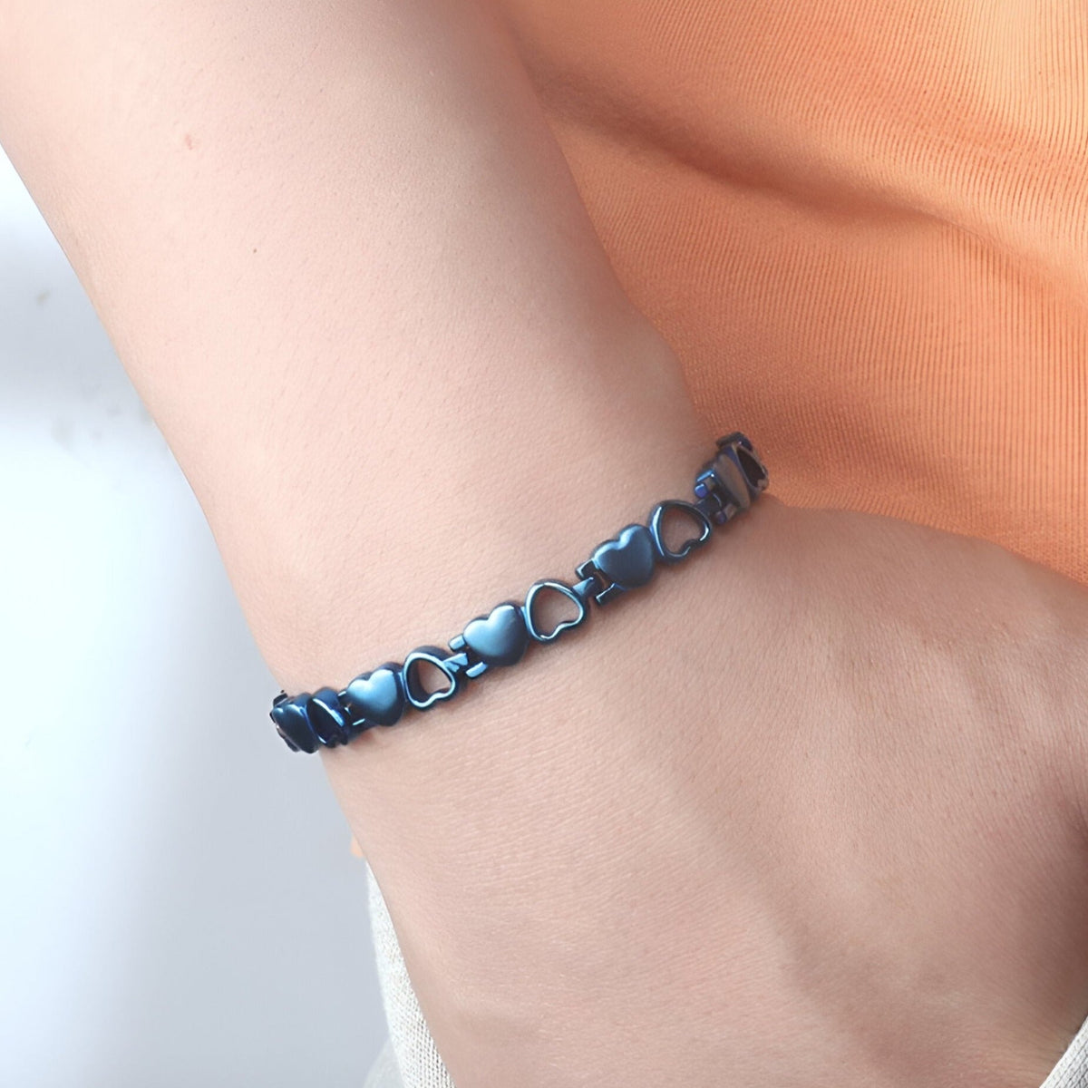 Bracelet magnétique en titane bleu avec maillons en forme de cœur pour femme.