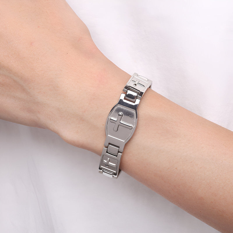 Bracelet magnétique en titane argenté avec croix chrétienne sur poignet homme.
