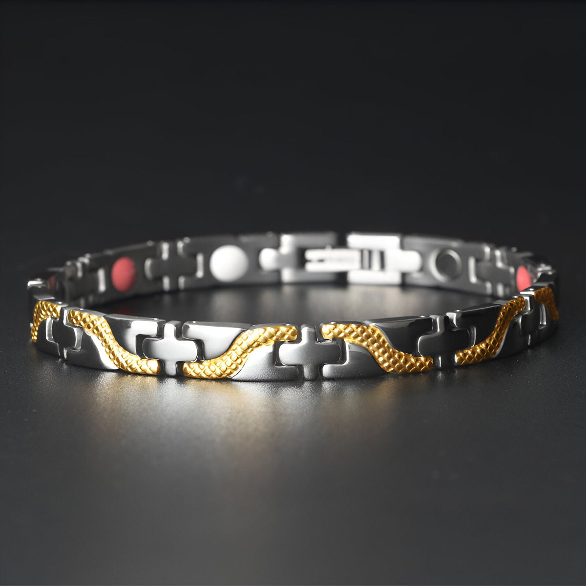 Bracelet magnétique fin en titane noir avec détails torsadés dorés et aimants rouges et blancs.