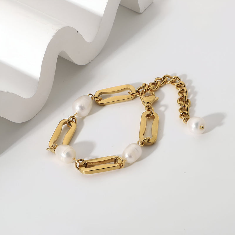 Bracelet en acier inoxydable doré avec maillons épais et perles d'eau douce blanches.