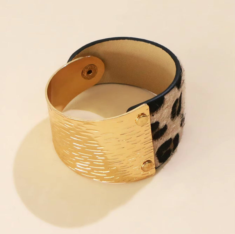 Bracelet manchette femme motifs léopard en cuir beige et détail métal doré texturé.