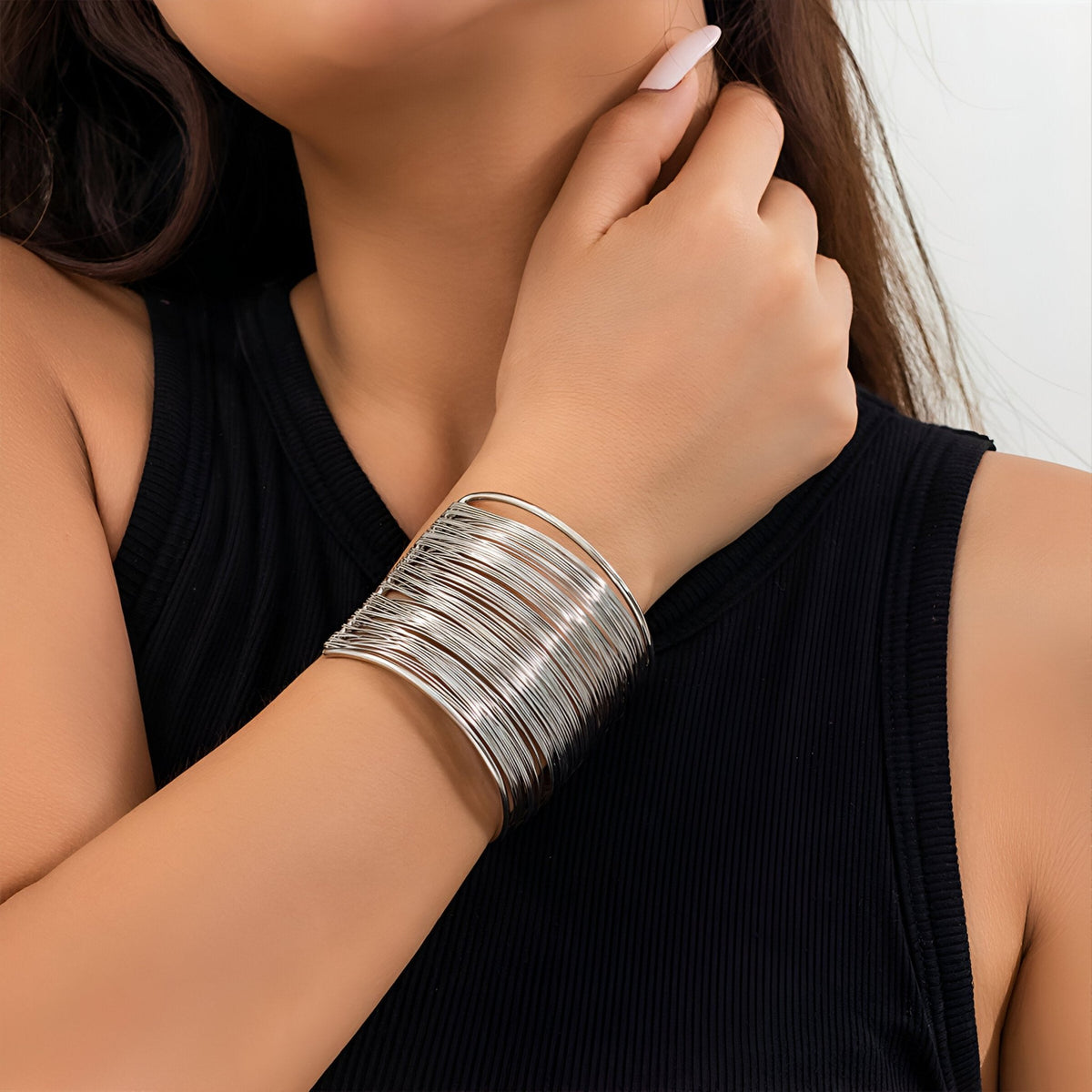 Bracelet manchette argenté aux multiples branches en alliage métallique porté au poignet.