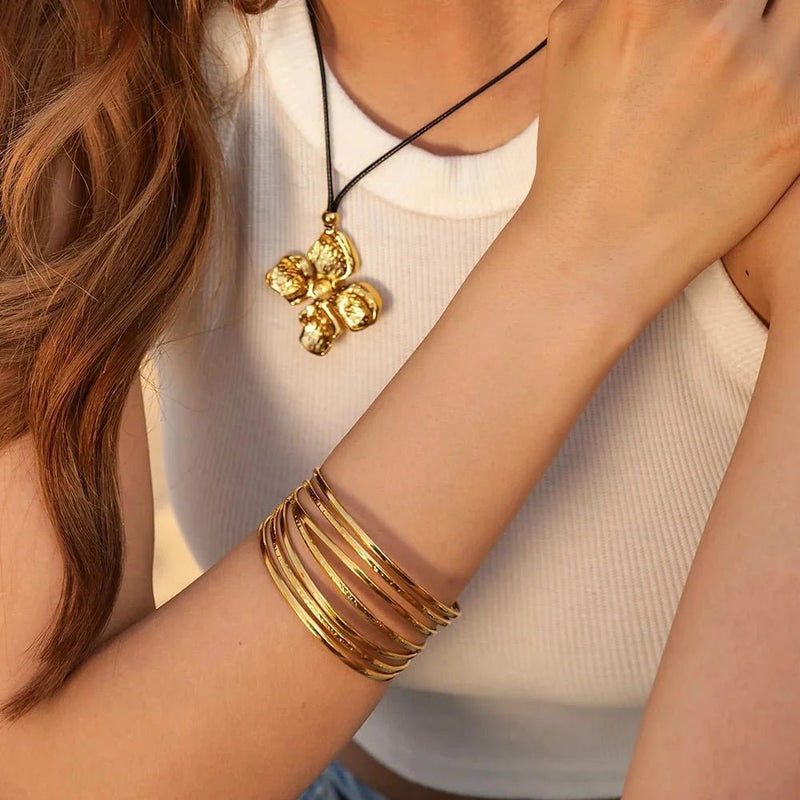 Brazalete dorado tipo manchette, diseño contemporáneo, de acero inoxidable, modelo Mouna