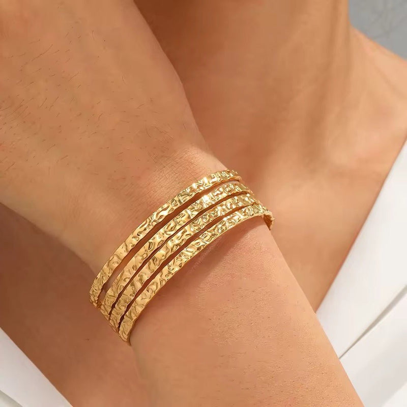 Brazalete tipo manchette dorado, con efecto martillado texturizado, de acero inoxidable, modelo Oris