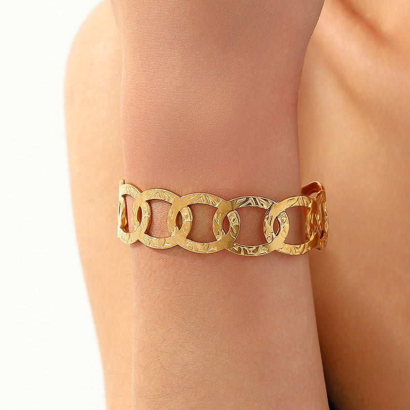 Brazalete dorado tipo manchette, óvalos entrelazados, de acero inoxidable, modelo Astraïa