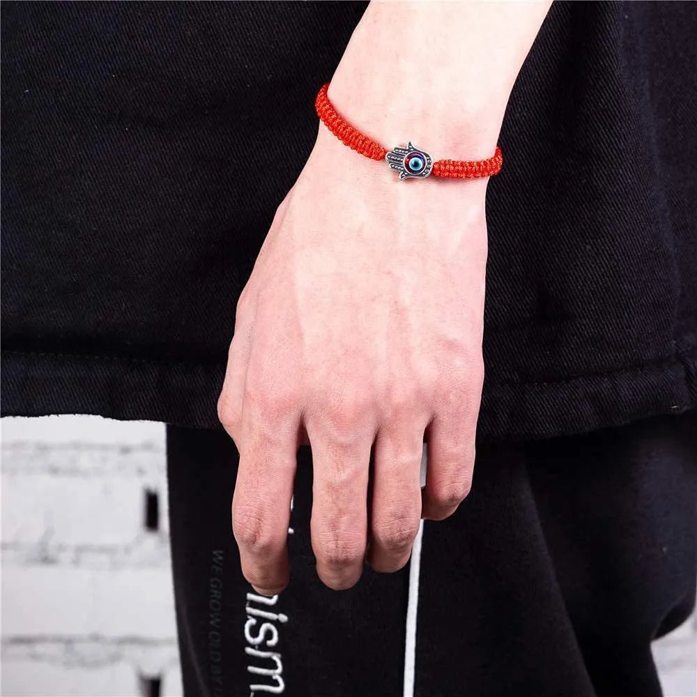 Bracelet fil rouge ciré avec pendentif œil bleu et main de Fatma, style minimaliste.