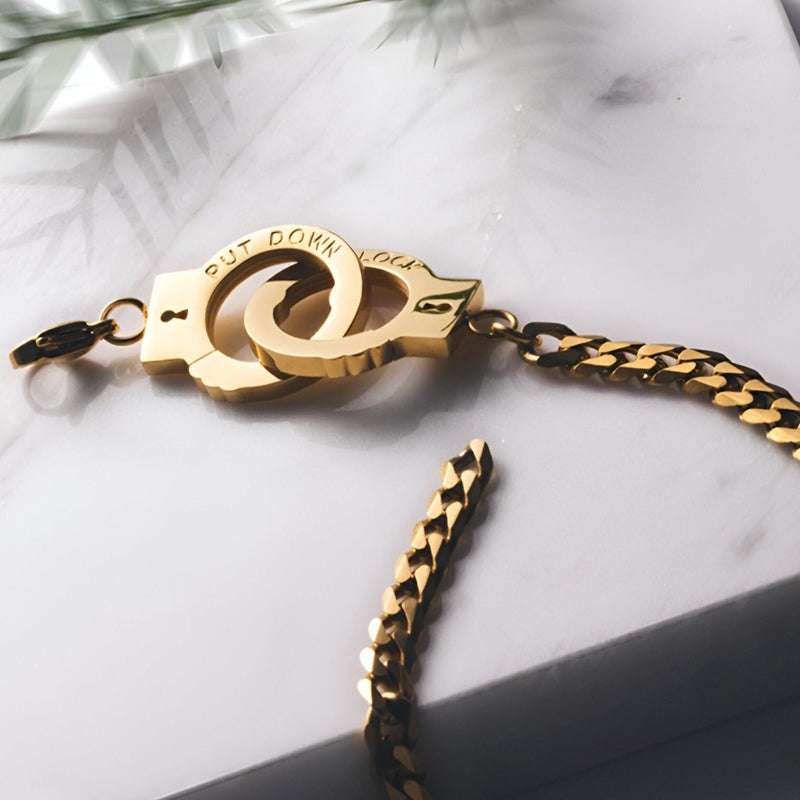 Bracelet menottes en acier inoxydable or rose avec maillons plats et fermoir original entrelacé.