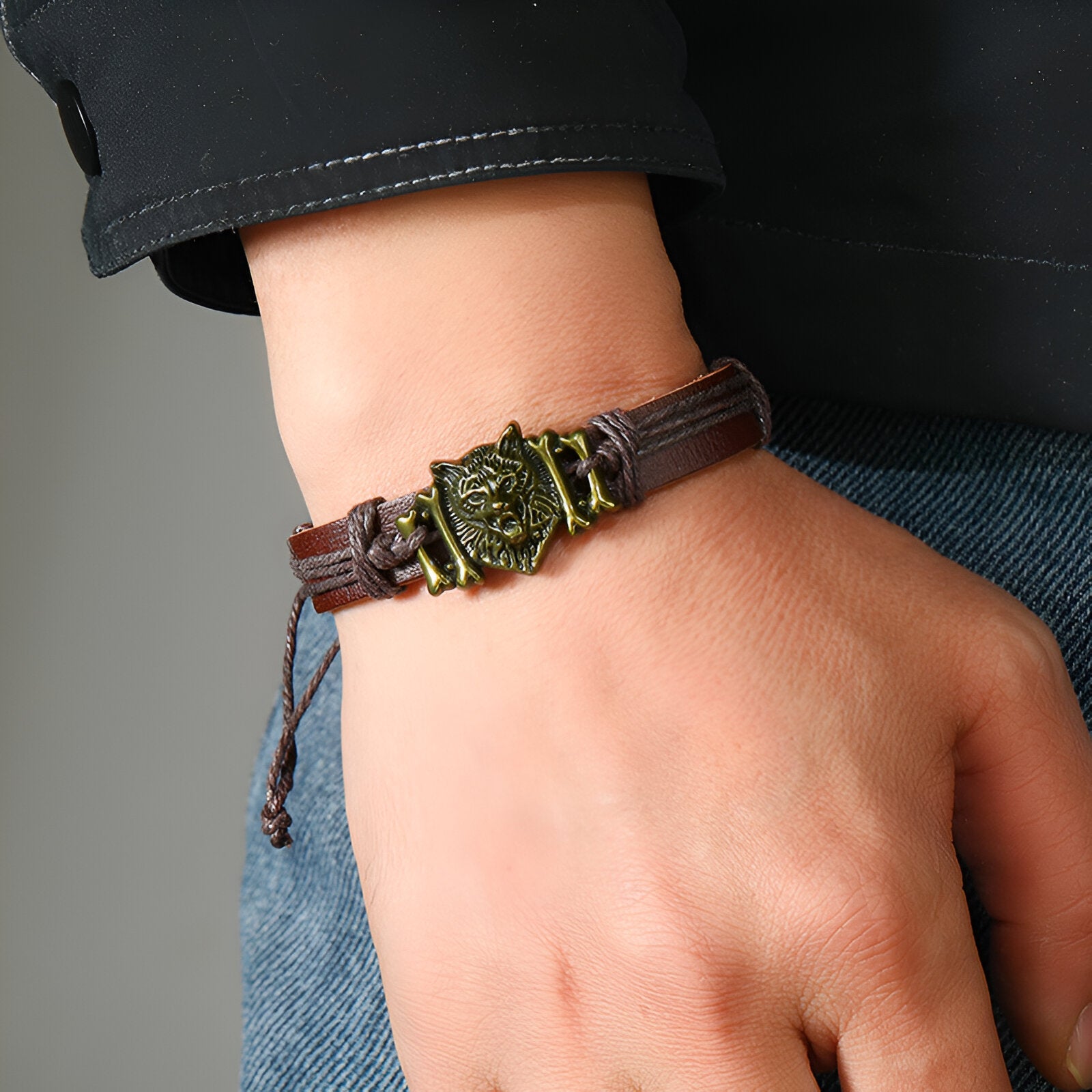Bracelet microfibre marron avec tête de loup hurlant dorée en détail central.