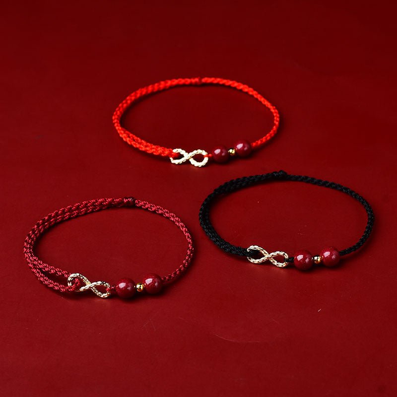 Trois bracelets minimalistes en fil ciré rouge, bordeaux et noir avec symbole infini en métal doré et pierres de cinabre.