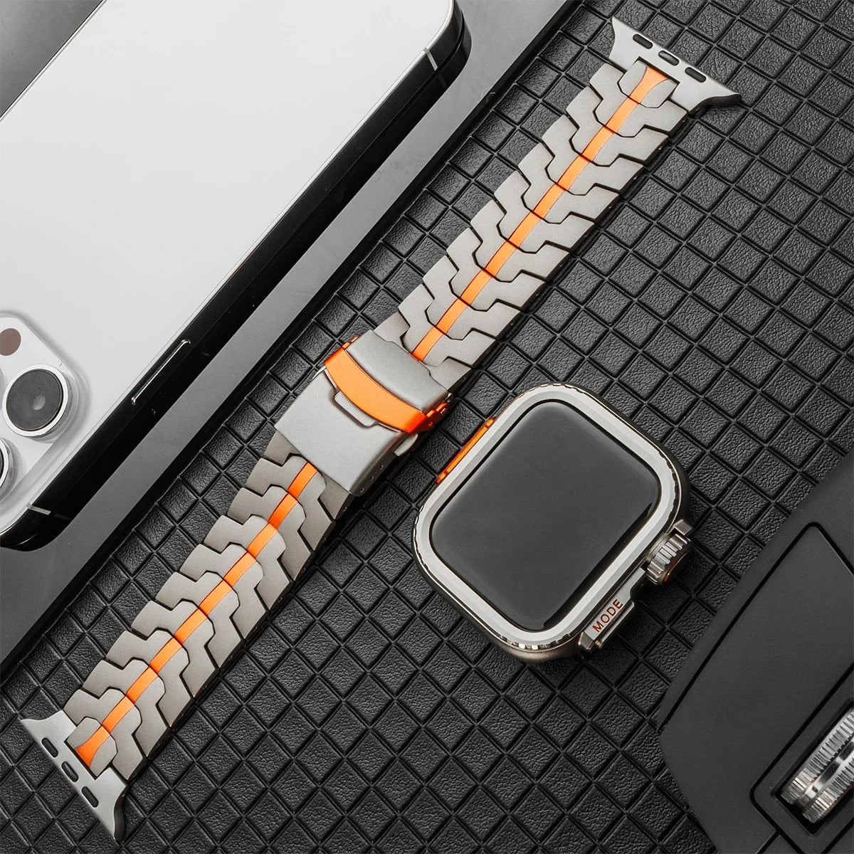 Bracelet montre en titane gris avec maille moderne et ligne orange centrale, boucle déployante robuste.