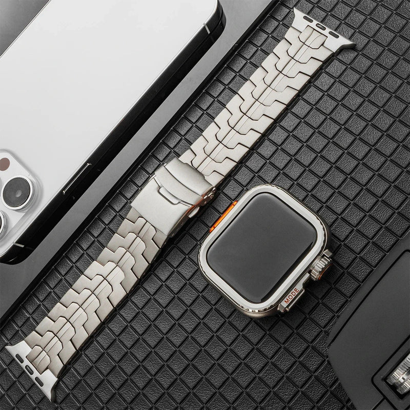 Bracelet montre Apple en titane avec maille robuste et ligne orange distinctive, boucle déployante métallique.