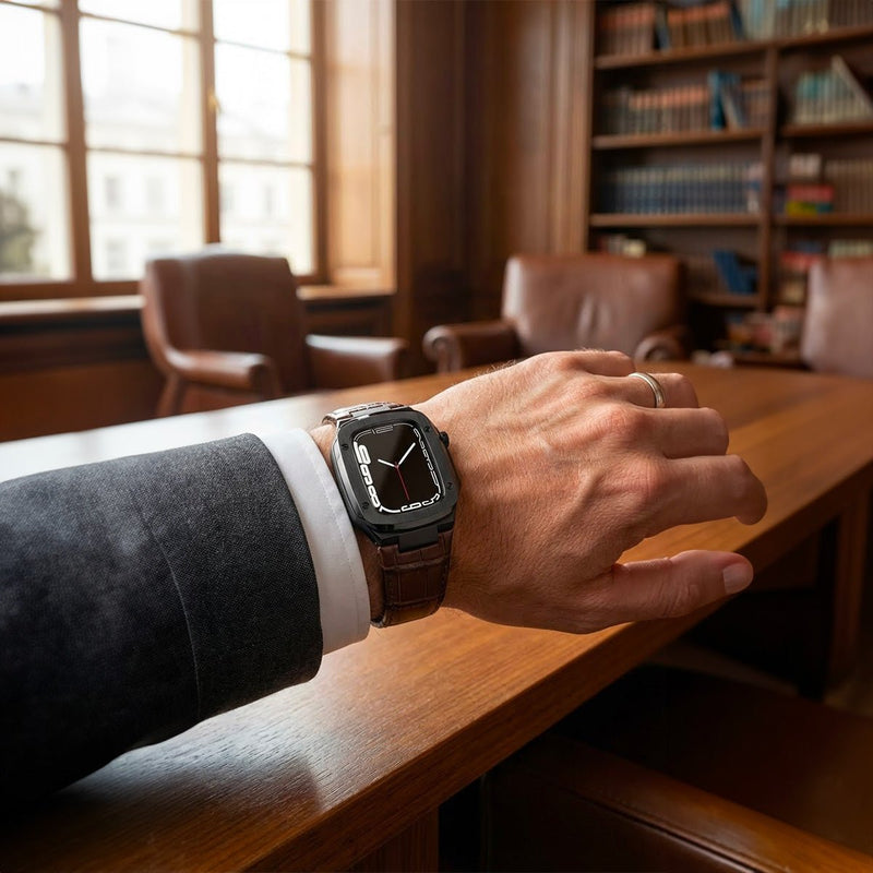 Bracelet montre cuir noir avec coque intégrée armure, boucle ardillon métal, porté au poignet homme.