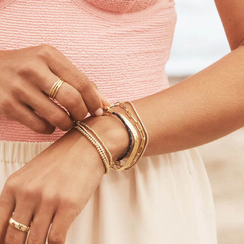 Bracelets en nylon beige et acier inoxydable avec mousqueton, style ajustable et moderne sur poignet féminin.