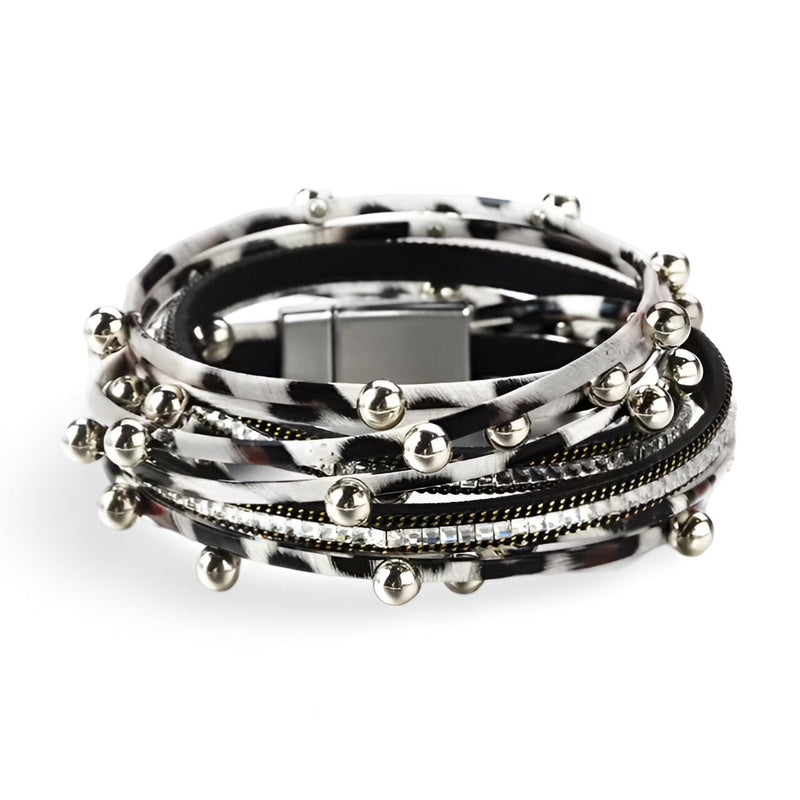 Bracelet multi-rangs noir et blanc avec breloques argentées et fermeture magnétique carrée.