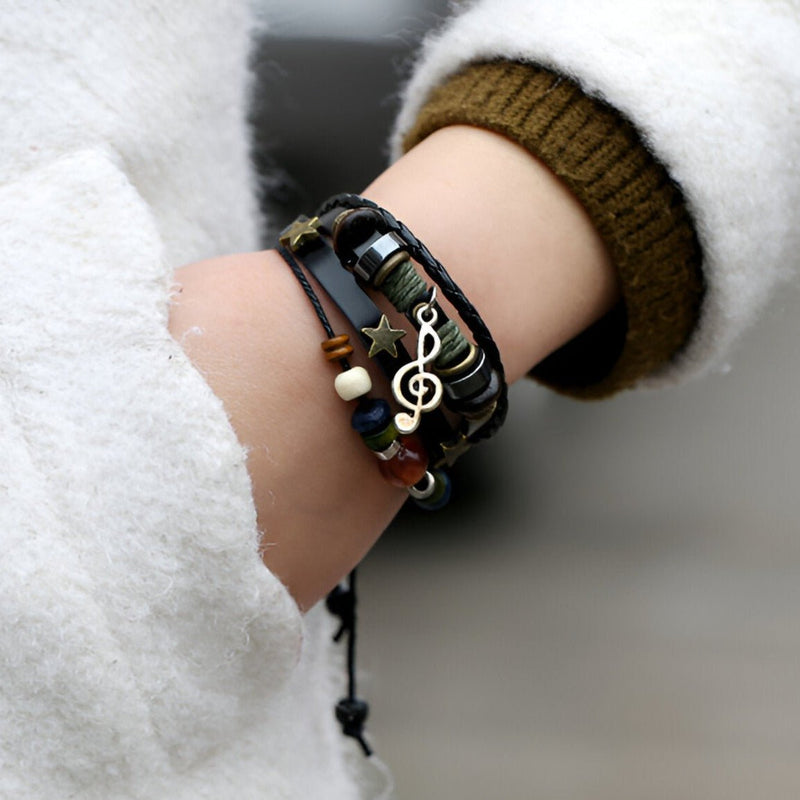 Bracelet multi-rangs en cuir noir avec perles, étoile dorée et pendentif note de musique argenté.