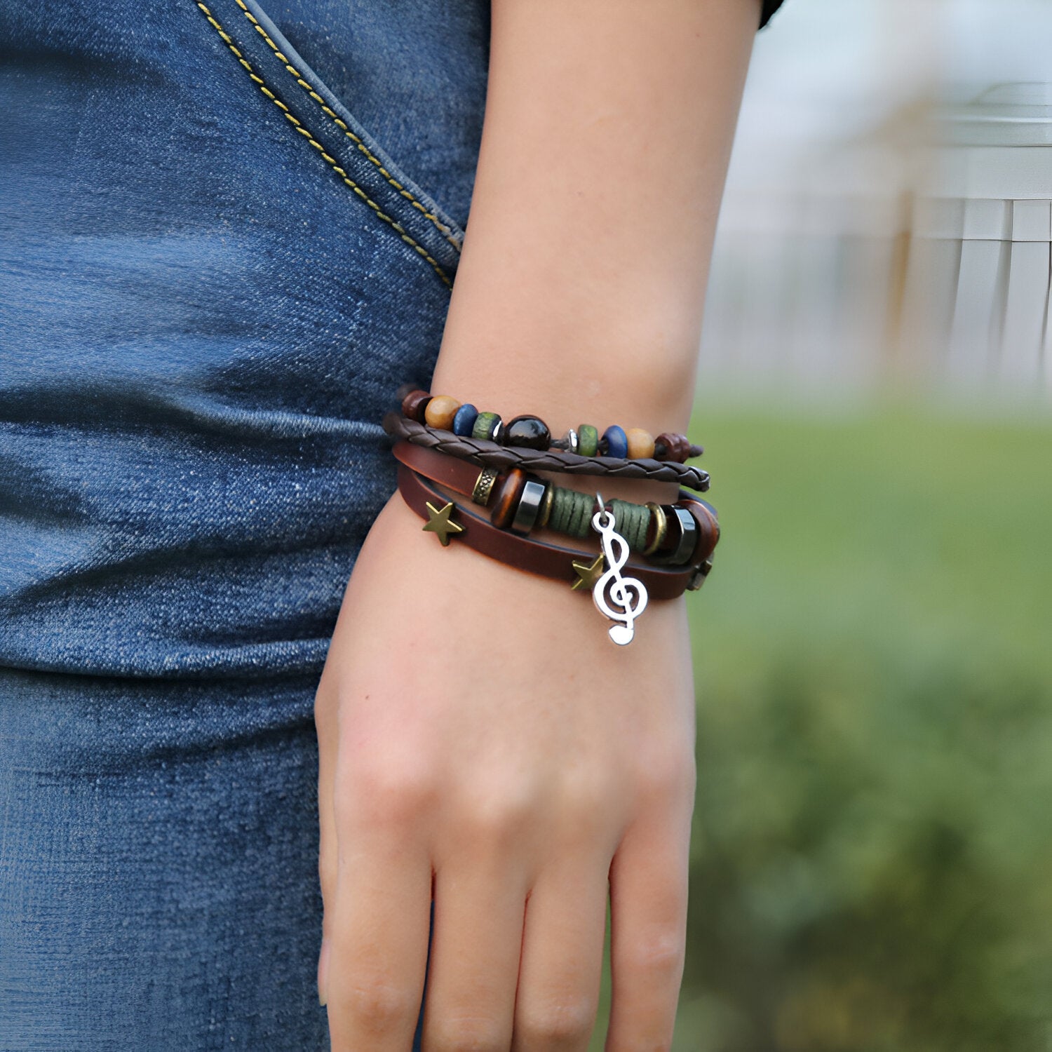Bracelet multi-rangs en cuir marron avec perles colorées et pendentif clé de sol argenté.
