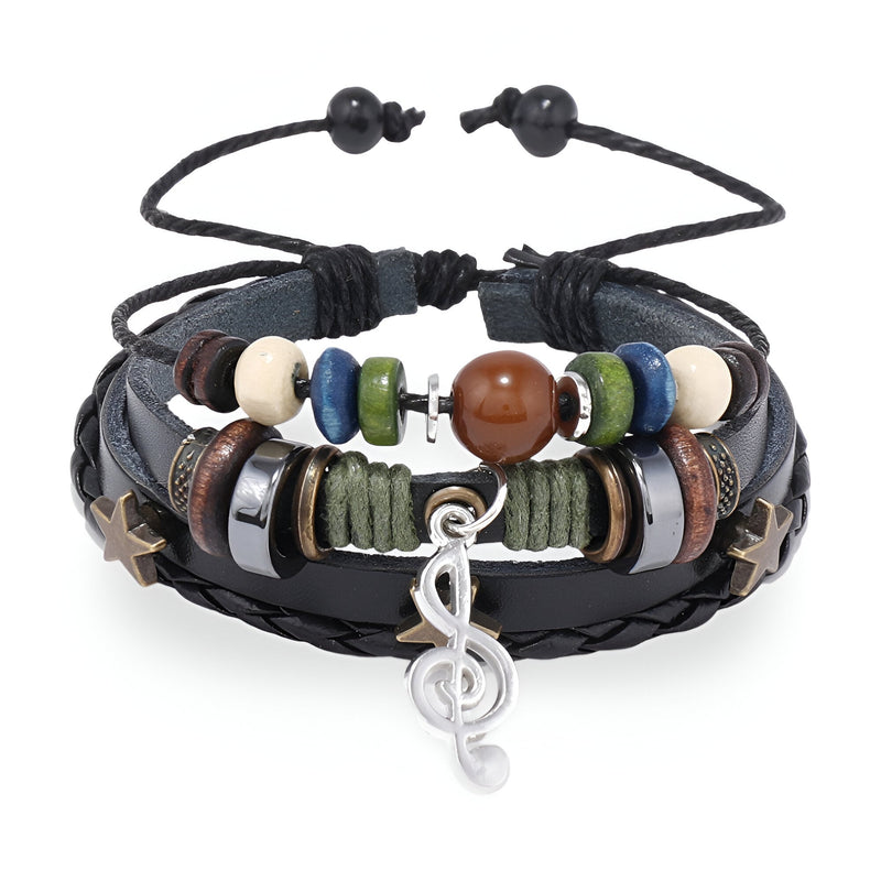 Bracelet multi-rangs en cuir noir avec perles colorées, breloques en métal dont une clé de sol argentée.