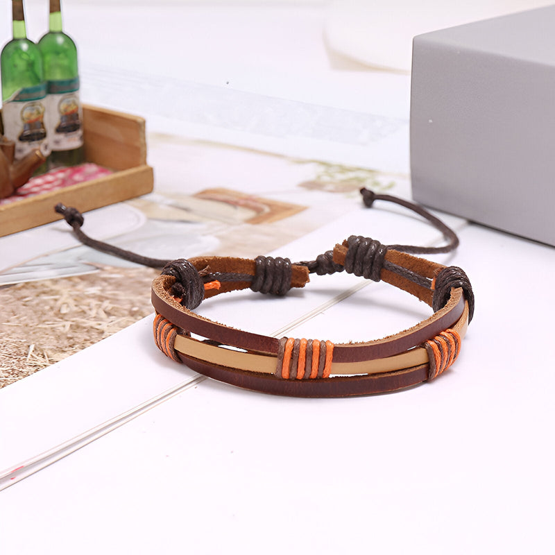 Bracelet multi-rangs en cuir marron avec détails orange et fermoir coulissant réglable.