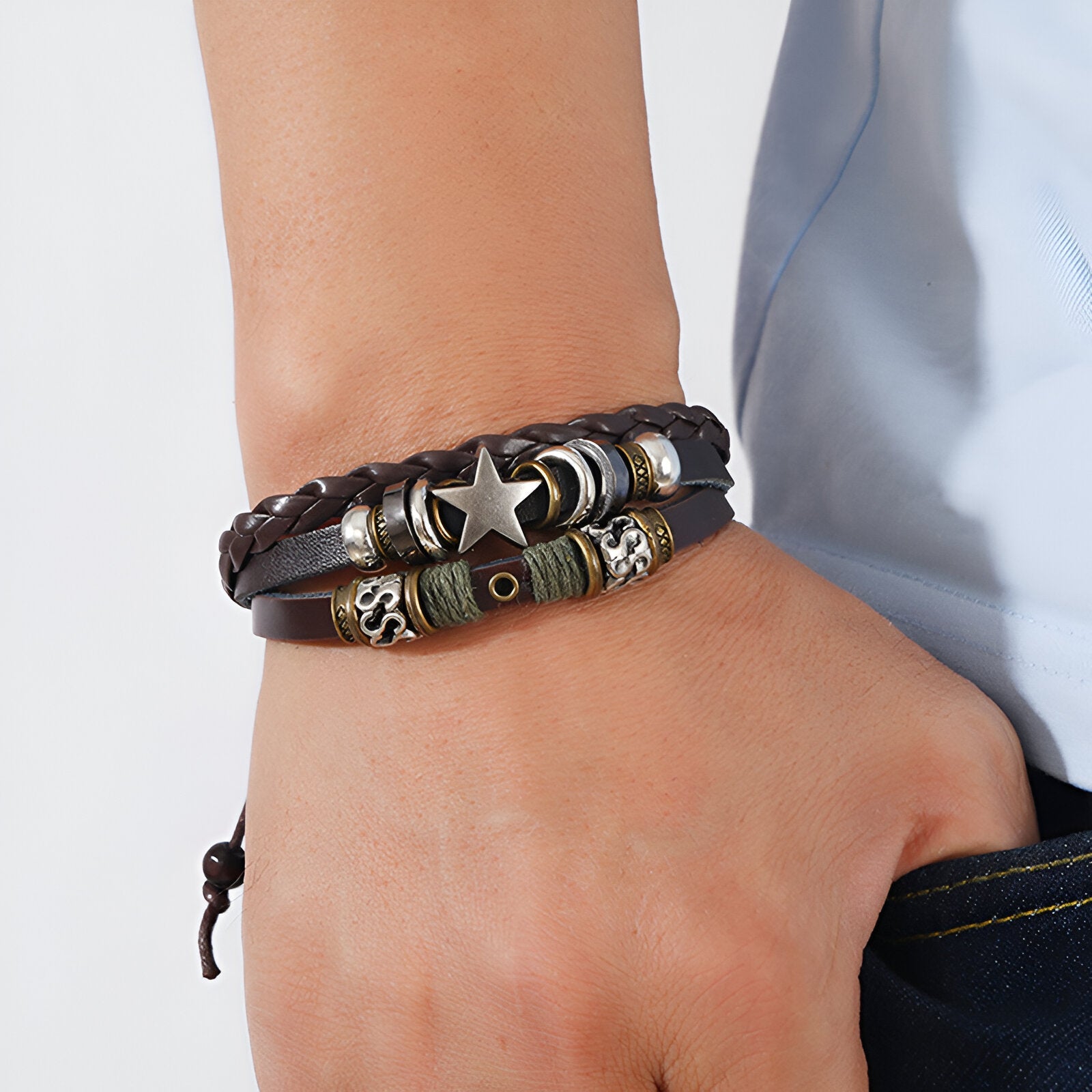 Bracelet multi-rangs en cuir marron tressé et bandes de bois ornées d'une étoile argentée et de perles décoratives pour homme.