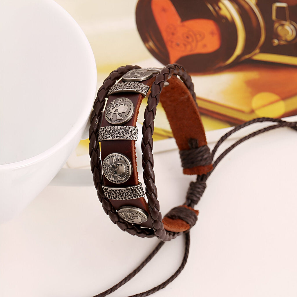 Bracelet multi-rangs en cuir marron avec têtes de mort en métal argenté, style vintage, ajustable.