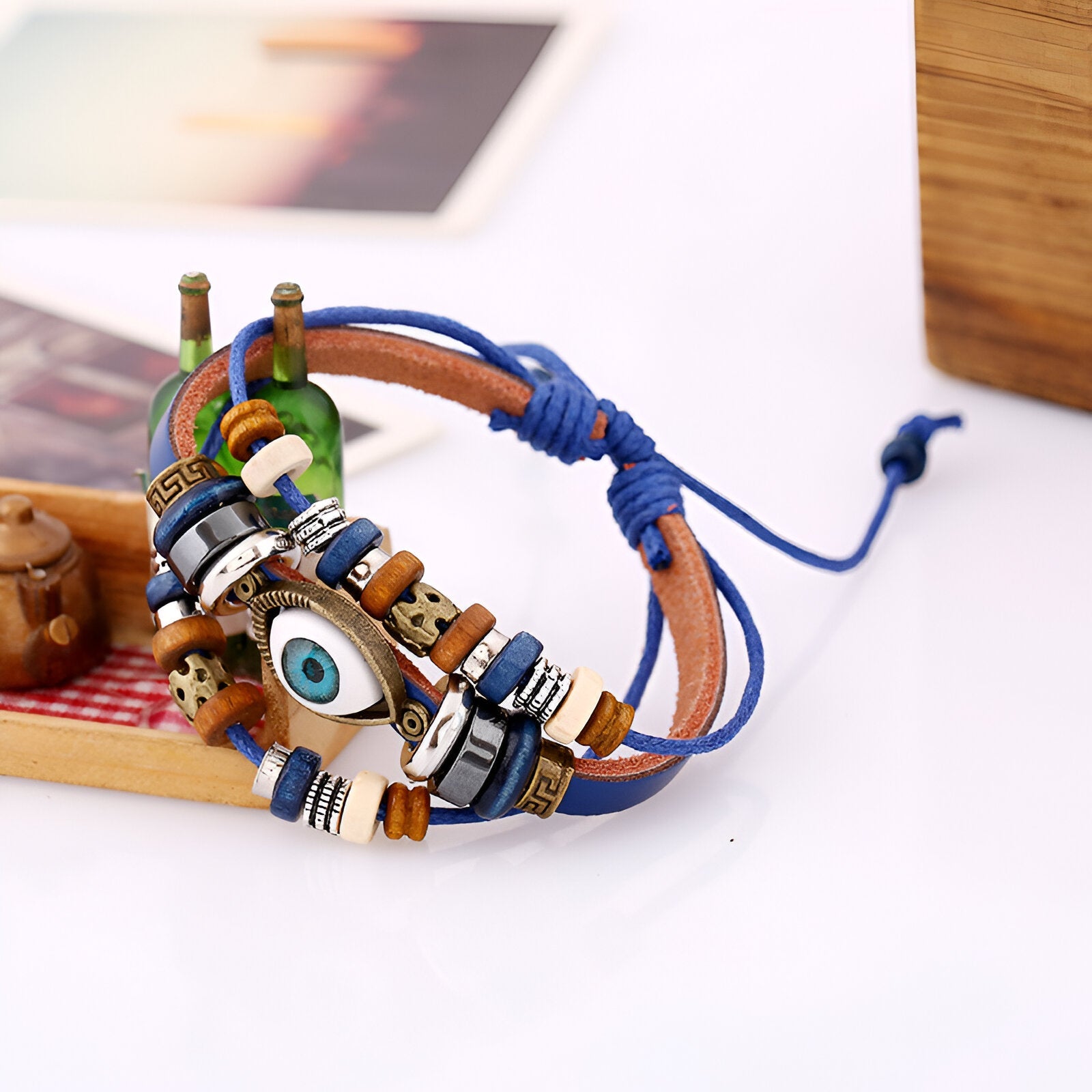Bracelet multi-rangs en cuir bleu avec perles en bois et pendentif œil de protection blanc et bleu.