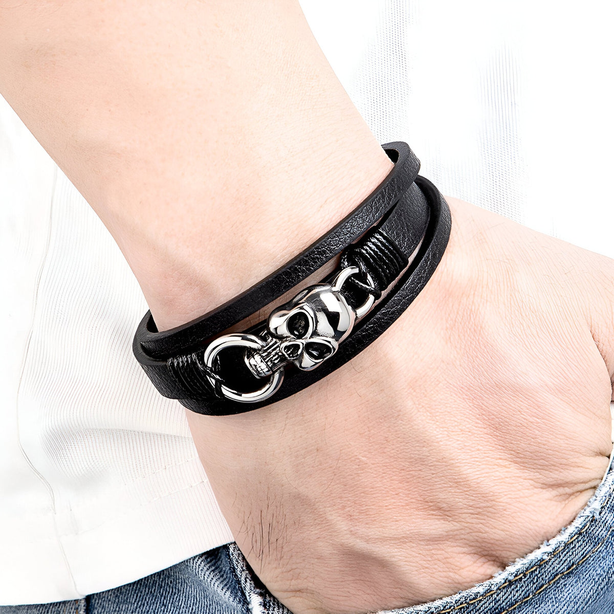Bracelet multi-rangs en cuir noir avec tête de mort argentée et anneau métallique élégant.