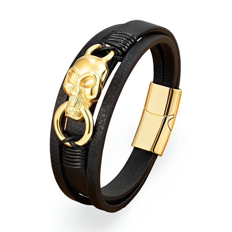 Bracelet multi-rangs en cuir noir avec tête de mort dorée et anneau, fermoir magnétique doré.