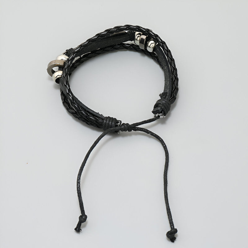 Bracelet multi-rangs noir en microfibre tressée avec plume métallique et fermoir coulissant.