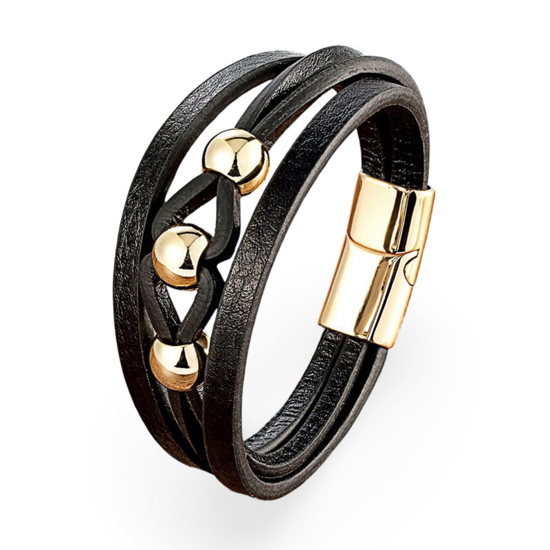 Bracelet multi-rangs noir en microfibre avec breloques métalliques dorées et fermeture aimantée.