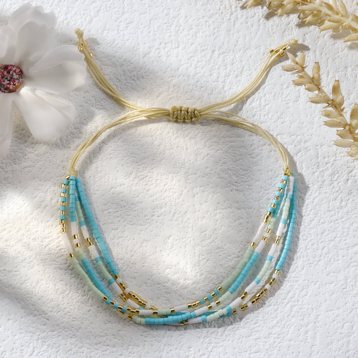 Bracelet multi-rangs bleu en perles heishi avec fil doré ajustable pour femme.