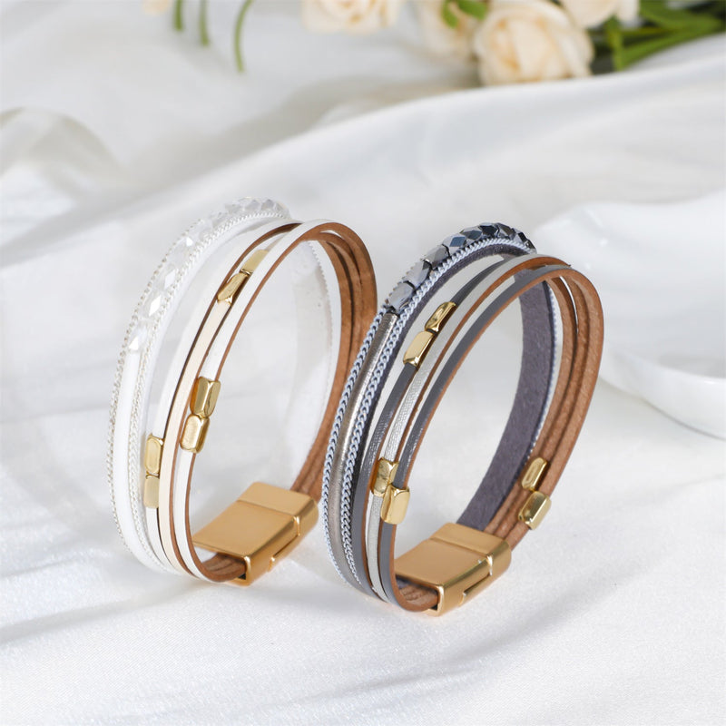 Bracelet multi-rangs blanc, marron et gris avec fermoir magnétique doré et détails métalliques bohémiens.
