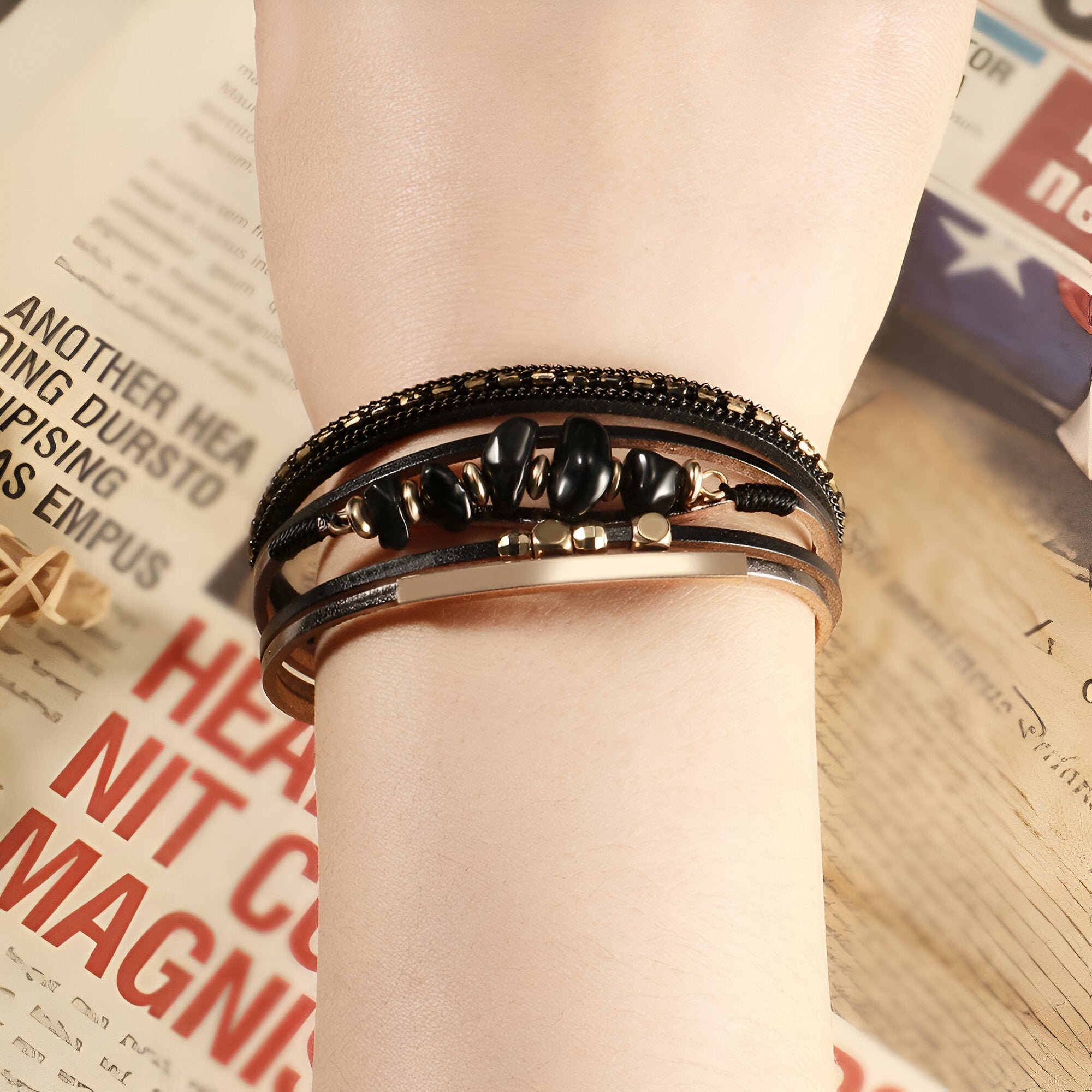 Bracelet multi-rangs noir avec pierres naturelles et perles style bohème sur poignet femme.