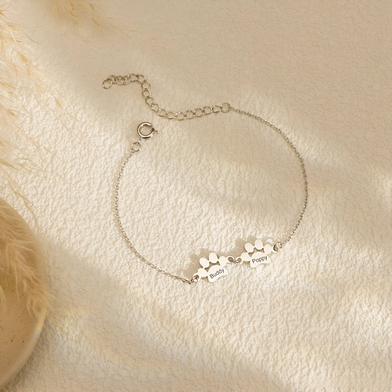 Bracelet fin en acier inoxydable argenté avec pendentifs de pattes gravées, design mixte.