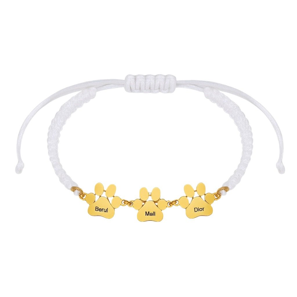 Bracelet blanc en nylon avec plaques en acier inoxydable doré gravées de trois pattes personnalisées.