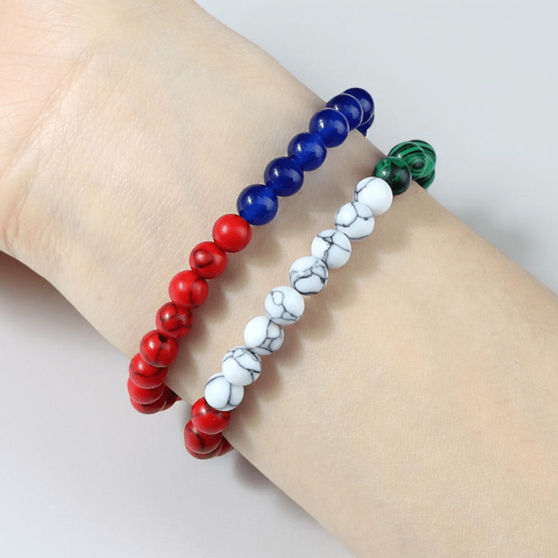 Bracelet tricolore perlé en pierres imitation rouge, blanc marbré et bleu sur cordon souple vert et rouge.
