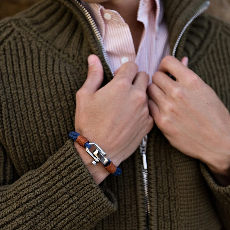 Bracelet homme en corde bleue avec fermoir mousqueton argenté et détail en cuir marron.