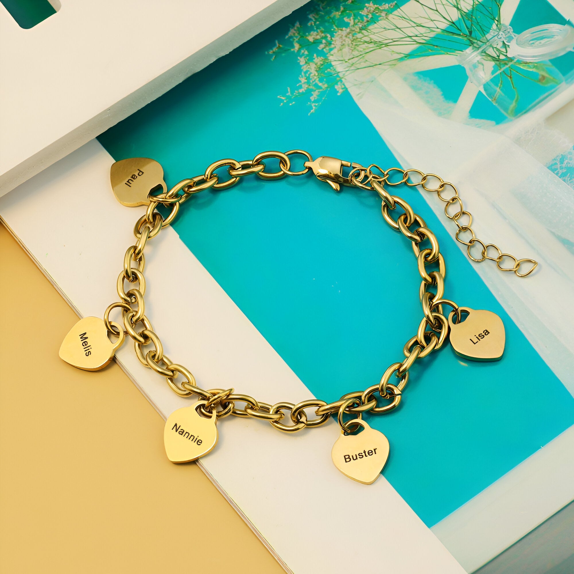 Bracelet en acier inoxydable or avec cinq plaques cœur gravées, chaîne à maillons épais et fermoir mousqueton.