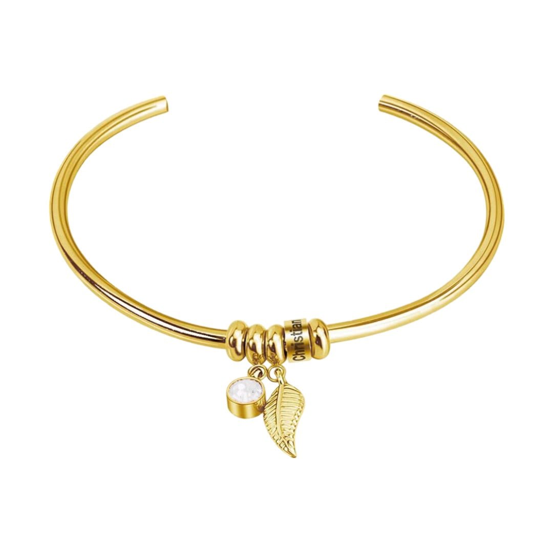 Bracelet jonc fin en acier inoxydable doré avec pendentifs plume et perle blanche.