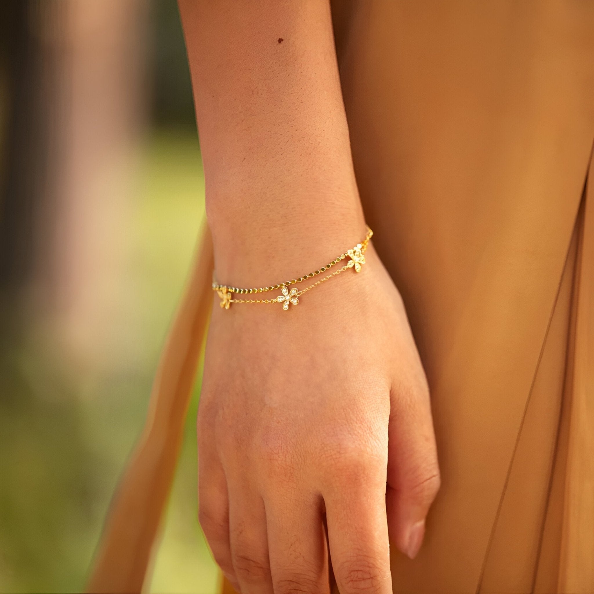 Bracelet en argent sterling doré avec petits pétales de fleur suspendus, style délicat pour femme.