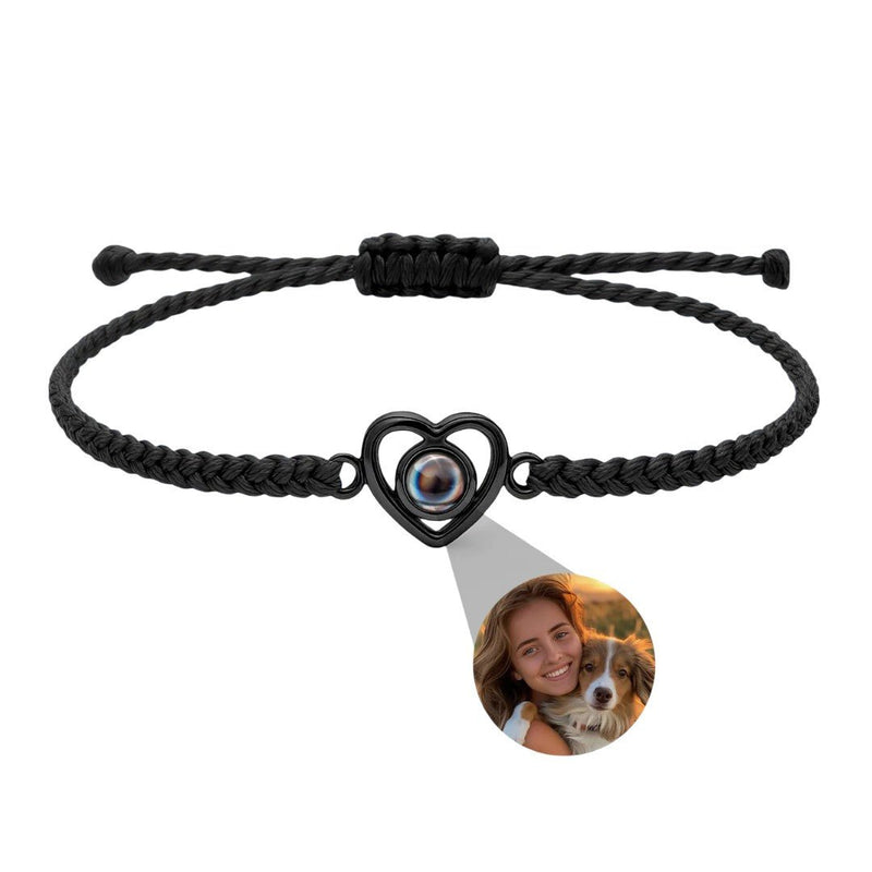 Bracelet noir tressé ajustable avec pendentif cœur en argent projetant une photo personnalisée ronde.