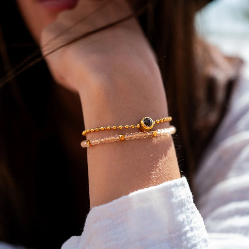 Bracelet double rang en pierres naturelles jaune miel avec médaillon rond doré, style délicat et élégant.