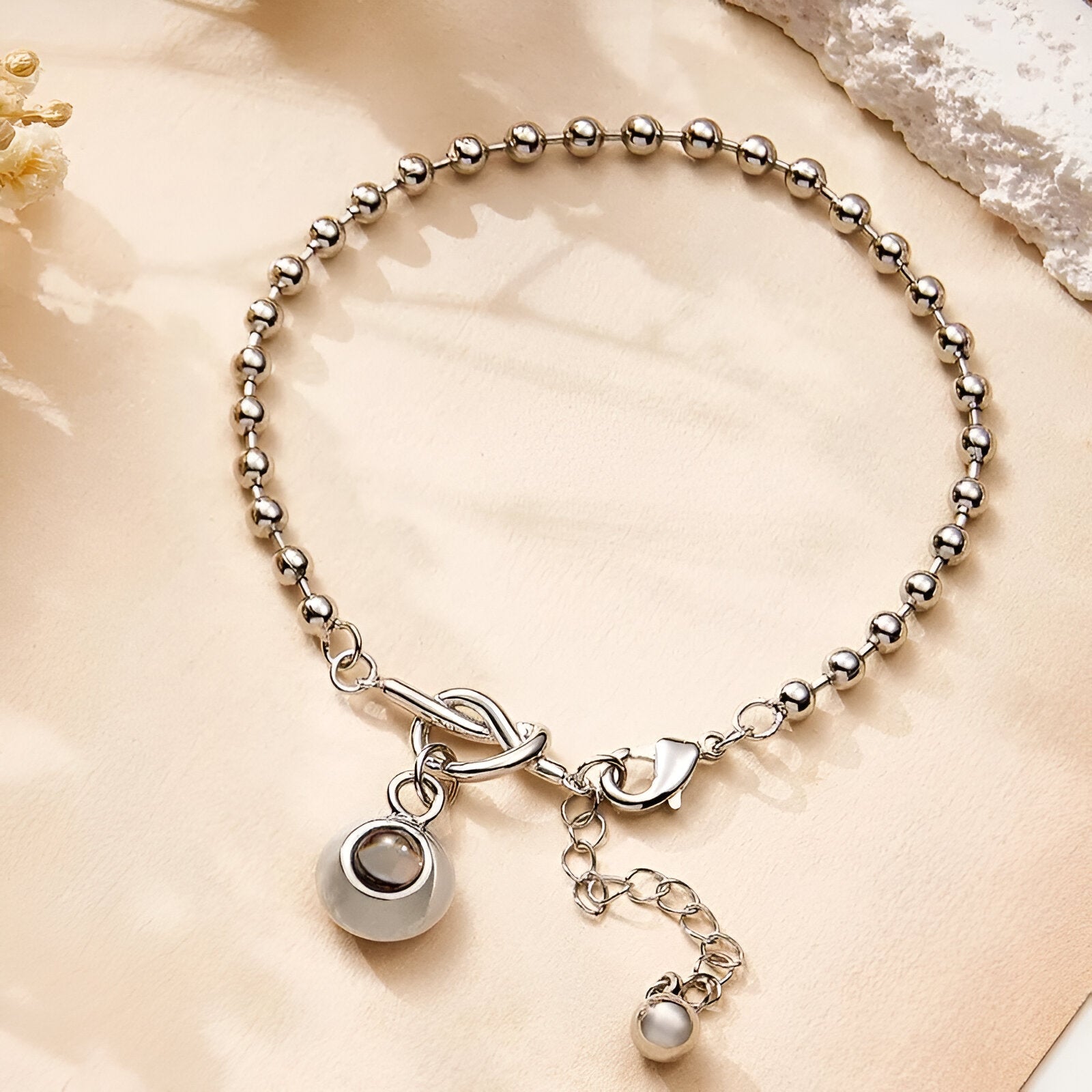 Bracelet à billes en acier inoxydable argenté avec pendentif photo rond et nœud central.