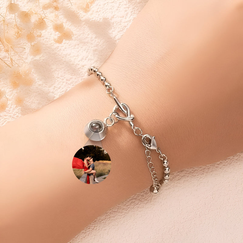 Bracelet en acier inoxydable argenté avec médaillon photo rond et nœud central sur chaîne fine.