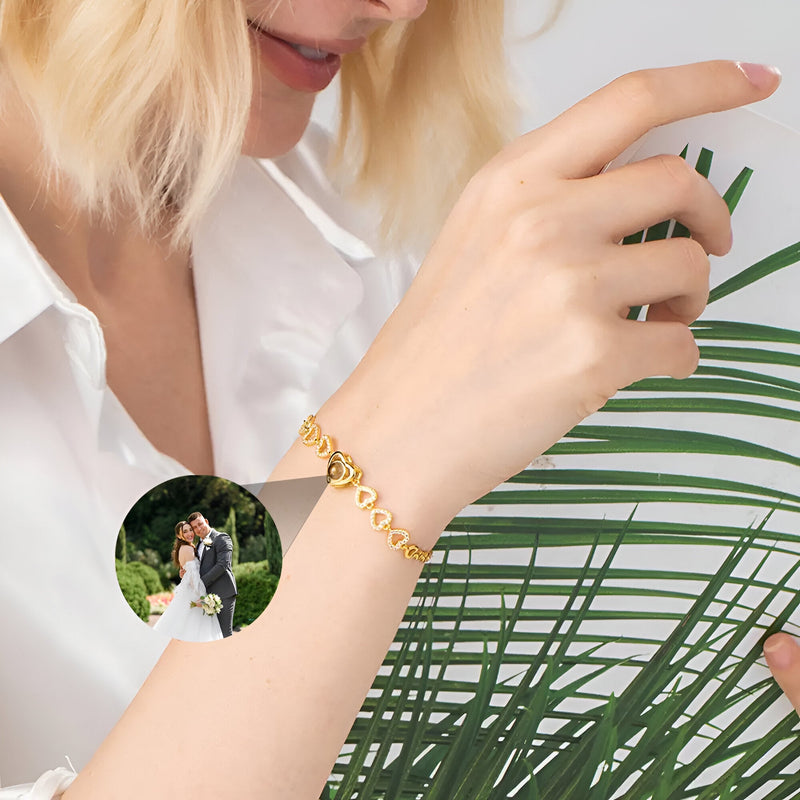 Bracelet en argent sterling avec multiples cœurs et médaille photo ronde personnalisée porté au poignet féminin.